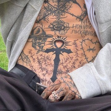 Tatuaż krzyża na męskim brzuchu, symbol siły i duchowości w centralnej kompozycji