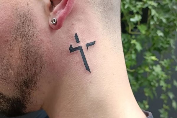 Męski tatuaż krzyż za uchem